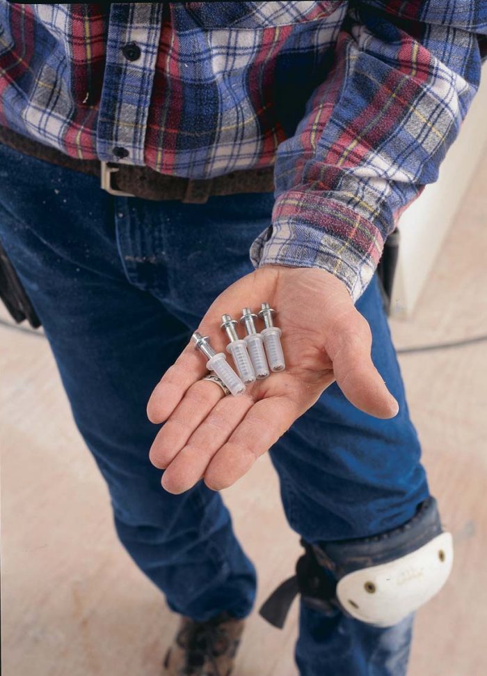 The doors swing on pins. At the top, each door has a spring-loaded pivot pin (photo left) that slides in the door track.