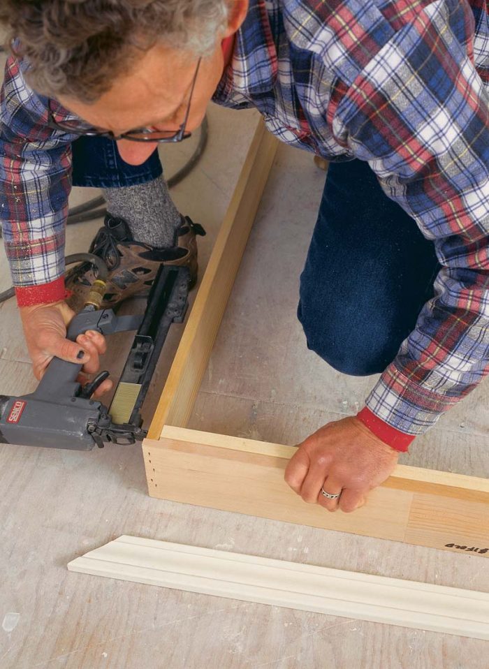 A 1x strip hides the door track. Once the jambs are assembled, the author attaches a 1x2 to the inside of the head jamb.