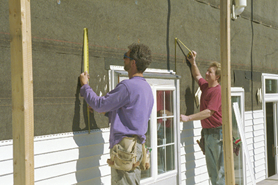 Man measures panels with measuring tape