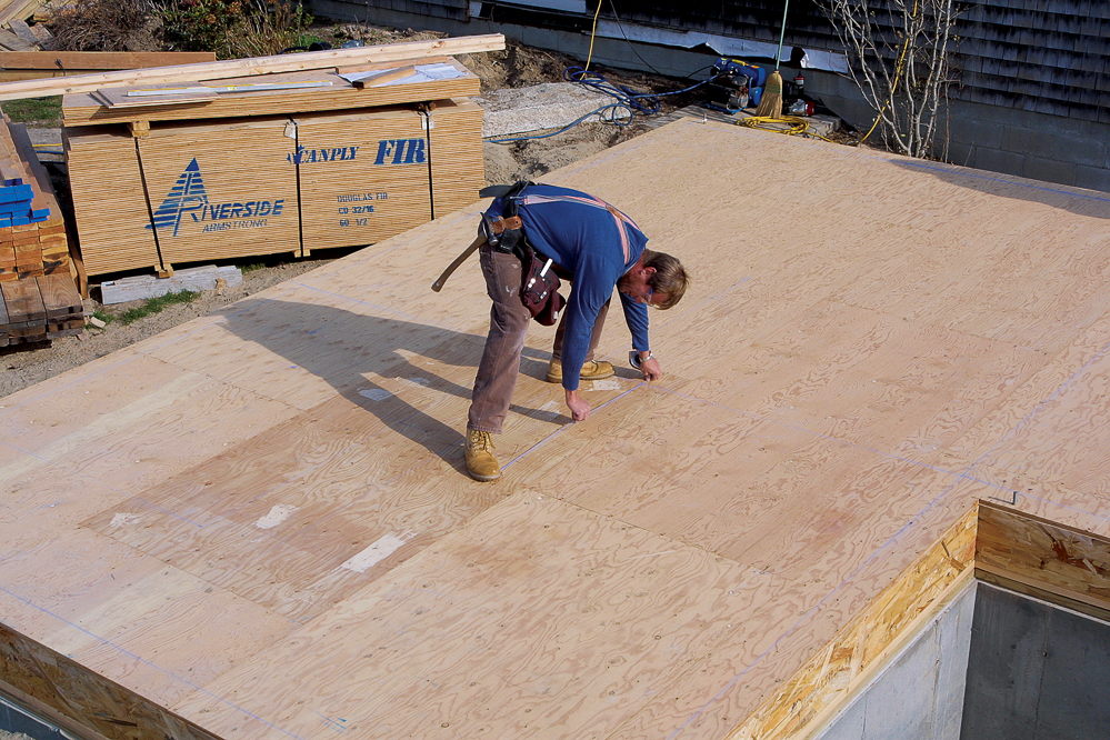 To snap chalklines for short walls, hook one end of the line to your boot and stretch the other end out to the mark. Rotating your foot slightly aligns the boot end, and you’re ready to snap