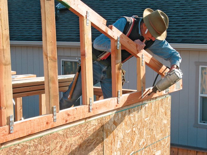 aligning the outside face of the truss flush with the wall sheathing below