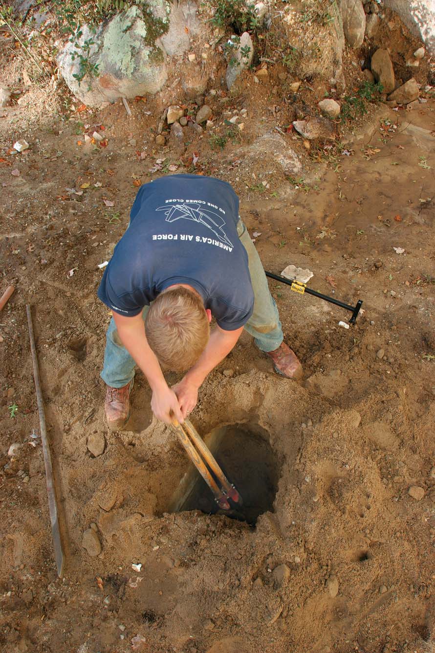 Using a long digging bar and a post-hole digger to not disturb batterboards or their settings.