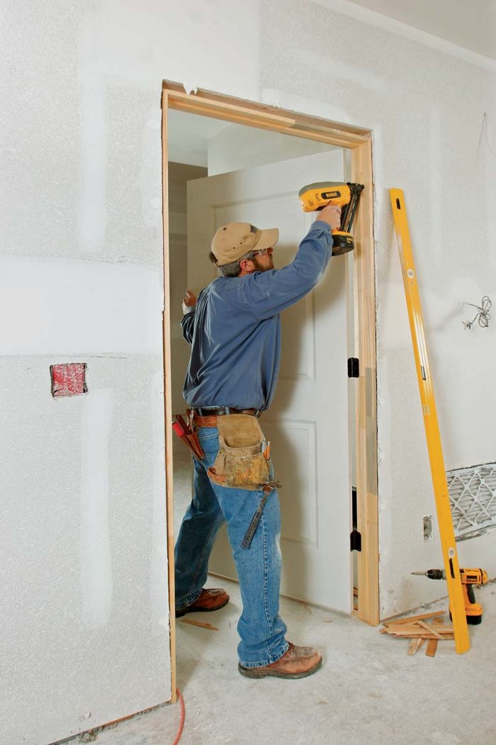 Start by nailing the hinge side in place. Then shim and nail the latch side to create an even reveal (or space) between the door and the jamb, about the thickness of a nickel.