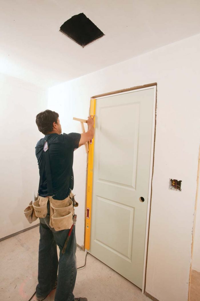 Speed Squares on both sides verify that the jamb is flush with the drywall.