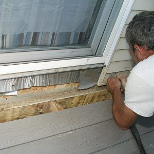 The thin aluminum ledger flashing is inadequate.