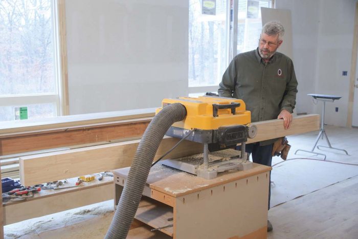 On edge. After ripping all of the stiles and rails about 1⁄8 in. wider than their final dimension on the tablesaw, send them through the planer to get them to their final width.