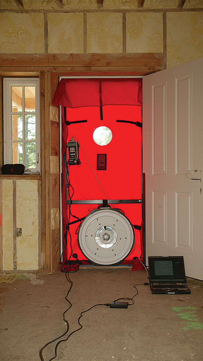 House with a blower door in the doorway is shown 