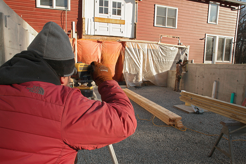  Pull a tape measure down from the top of the stem wall, and sight the tape in the crosshairs of the builder’s level. Note that measurement, and swing the scope to the story pole.