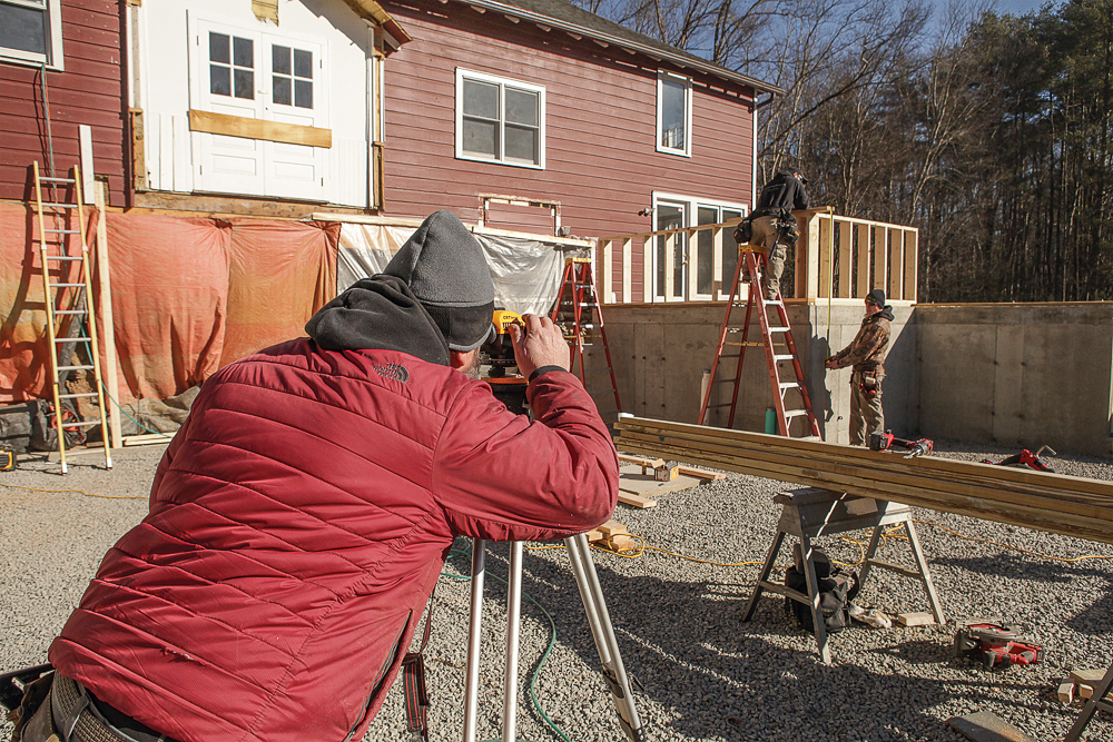 Tack a scrap of 2x on top of the cripple wall to represent the double top plate, then pull a tape down from it and sight the measurement with the builder’s level. Then pull a measurement from the screw marking the joists on the story pole. The two measurements should match.