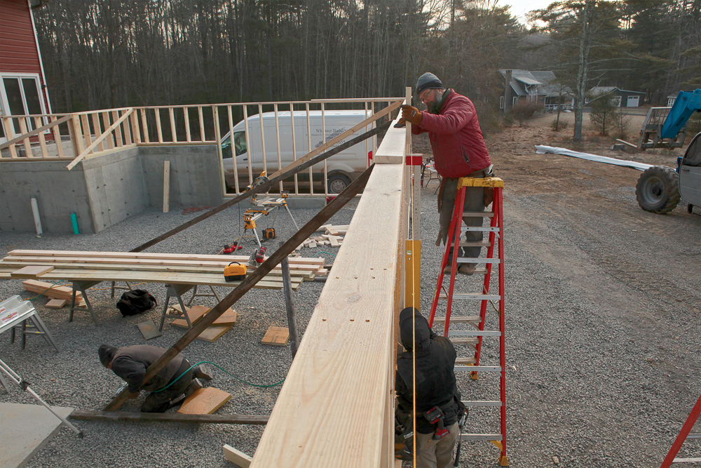 Use a stringline and gauge block to straighten walls, and check for plumb with a plate level. Lumber wedged between footings and the mudsill and tacked in place provides nailers for bracing where the ground is too frozen or unstable for stakes.