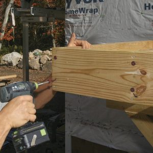 Secure the rim joist. Screw the rim joist into the ends of the joists on each side of a post position with 6-in.-long FlatLok screws. Normally these fasteners don’t require pilot holes, but I use them at these end locations to keep the rim joist from splitting.