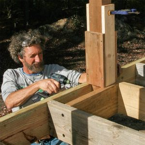 Screw the post to the rim joist. A pair of 8-in. ThruLoks tie the rim, post, and blocking together.