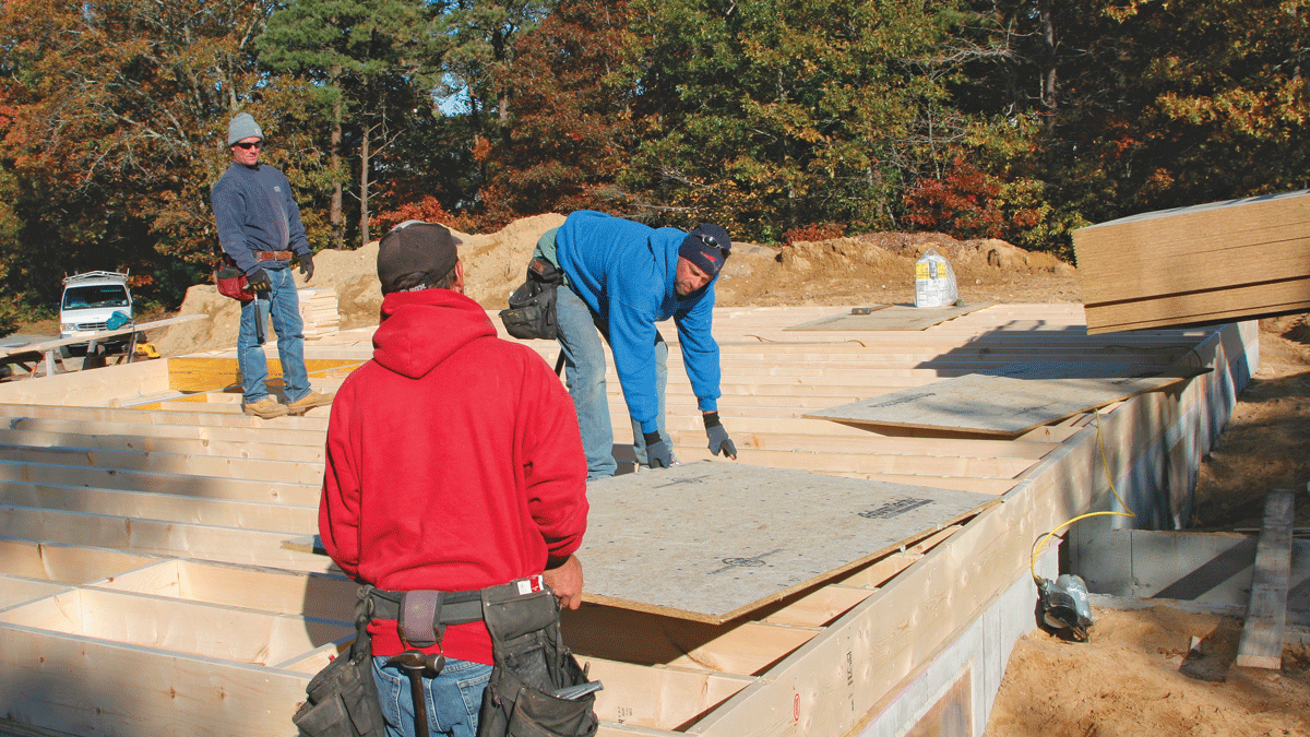 The first piece of sheathing should be placed carefully to avoid smearing the adhesive. It’s a job for two people.