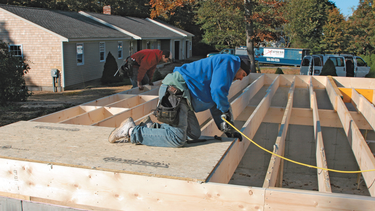 When the first sheet is in place, tack a corner to hold it at the centerline of the joist (photo 66). Then nail it to the remaining joists, guided by the layout marks printed on the sheathing (photo 67). This prevents the joists from wandering off course as subsequent sheets are installed.