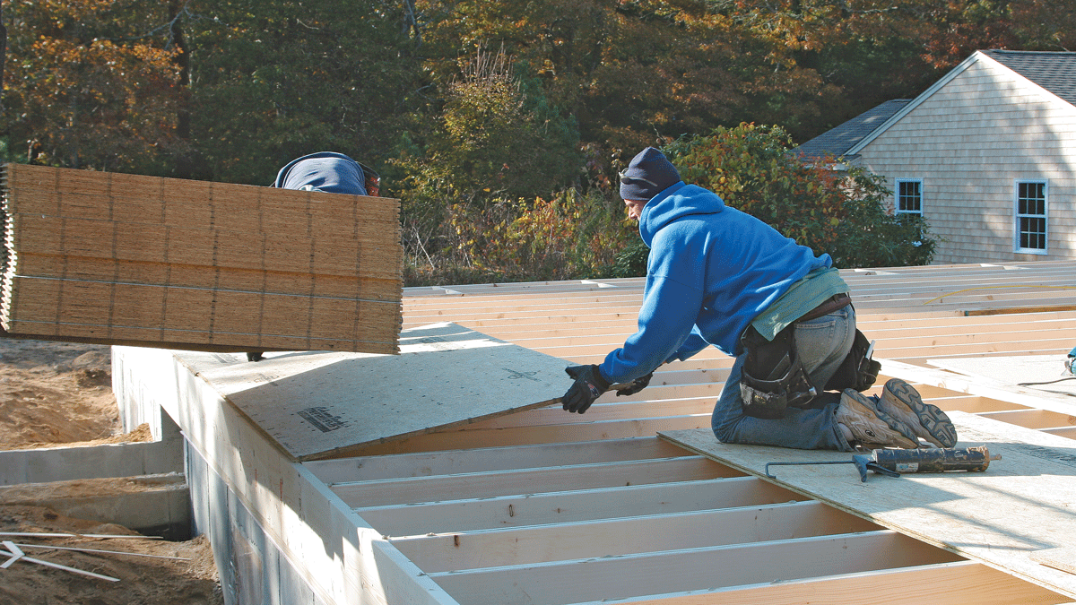 The rest of the first row of sheathing goes on in the same way as the first sheet. Nail the first course completely so the sheets will bond to the adhesive and withstand the pounding needed to get the subsequent rows into place.