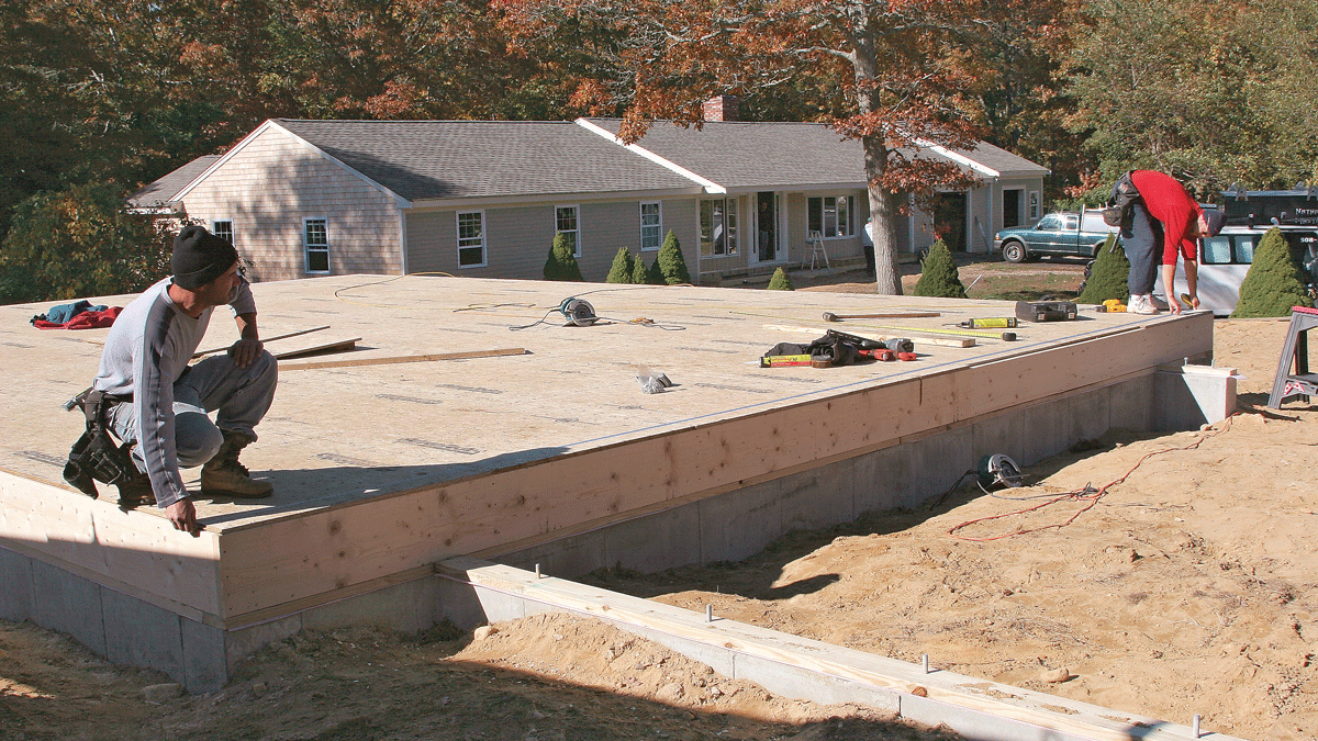 To straighten the rim joist, snap a straight line and measure over to the line from the face of the rim. Adjust the rim in or out as necessary, and then nail it to the edge of the sheathing.