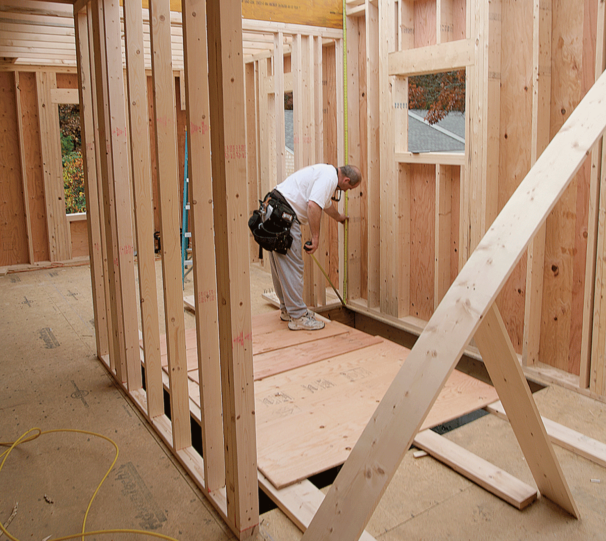 For new construction with perfectly level floors, the measurement for overall rise can be taken anywhere. Here, the measurement taken at the back of the chase also locates the height of the landing.