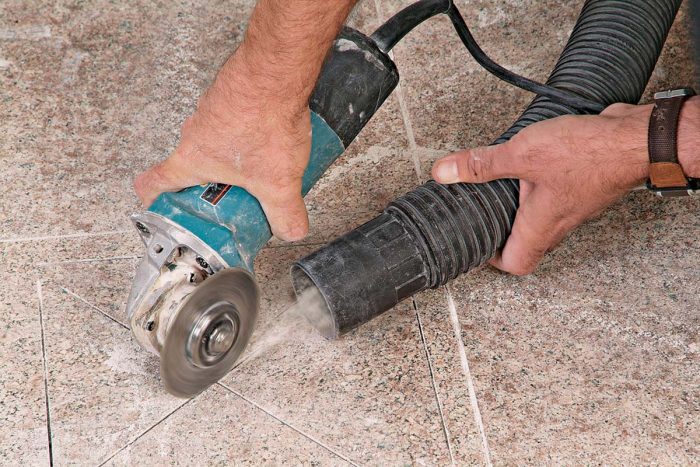 A vacuum held near the grinder will reduce the amount of airborne dust.