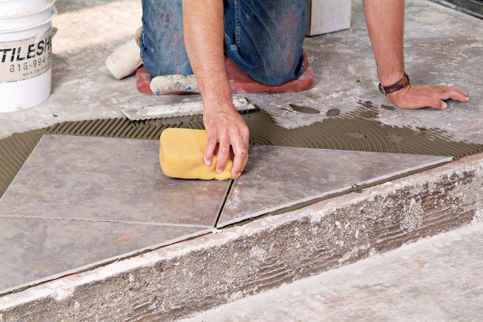 Clean up wet thinset drips from the face of the tiles with a damp sponge.