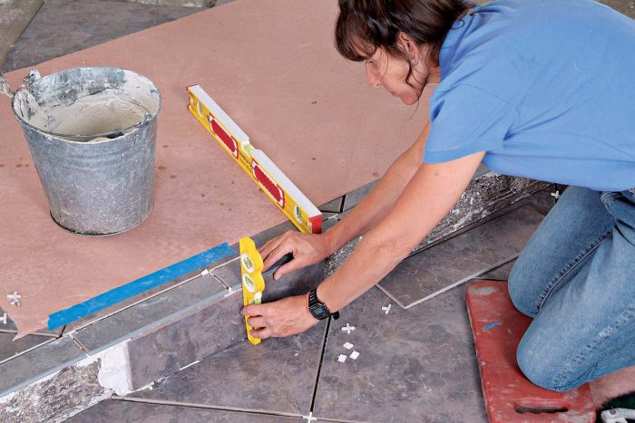 Use a torpedo level to make sure that the riser tiles are plumb and even with the edge of the bullnose tiles.