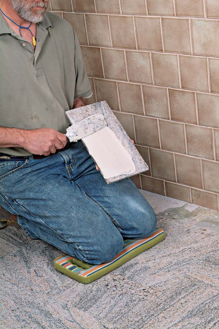 Back-butter cut stone tiles before setting them in place.