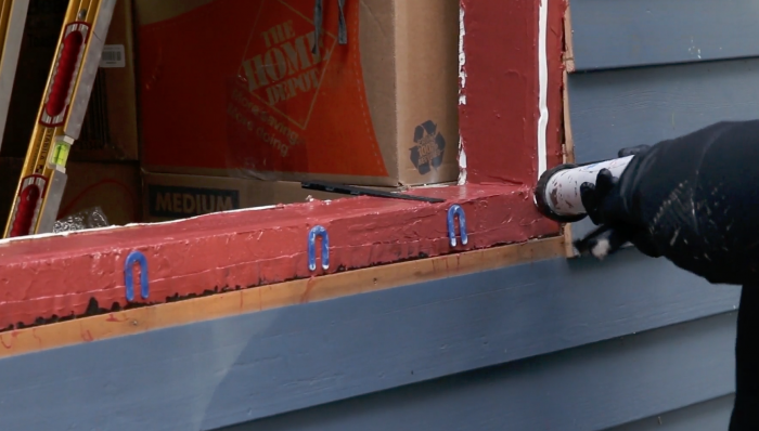 blue horseshoe wedges create a gap at the bottom of the window so that the sill can drain if water is ever gets in.