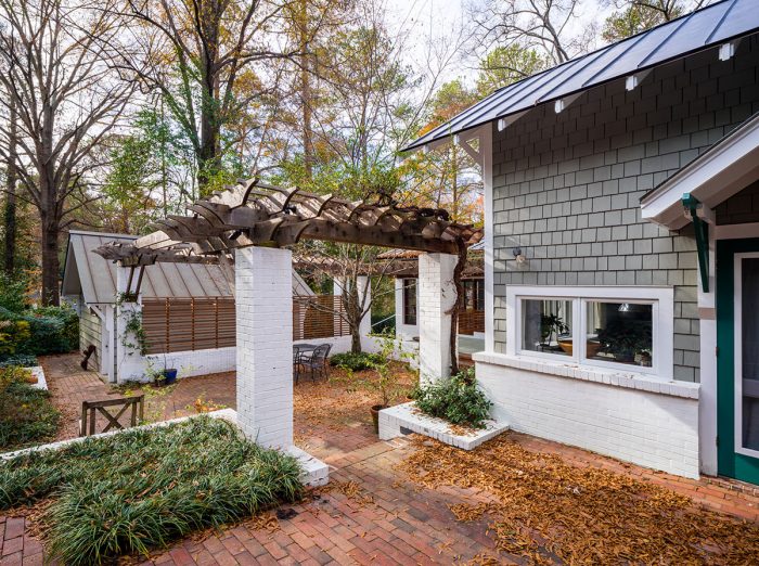 An after photo of the same house but an outdoor space with a pergola and a courtyard