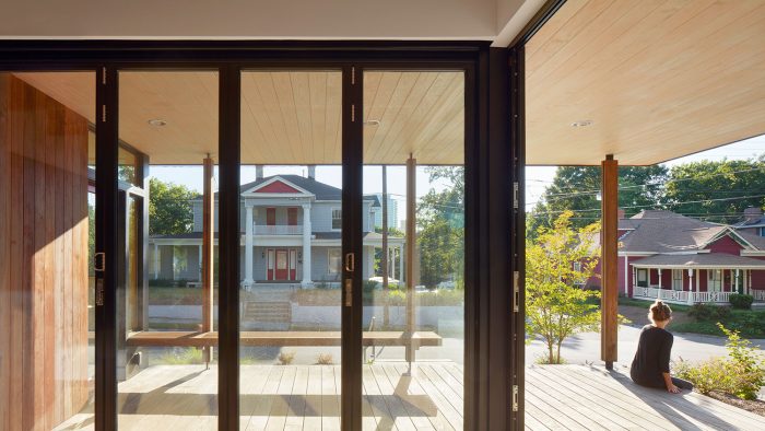 A view through glass doors to a window sitting on a porch outside