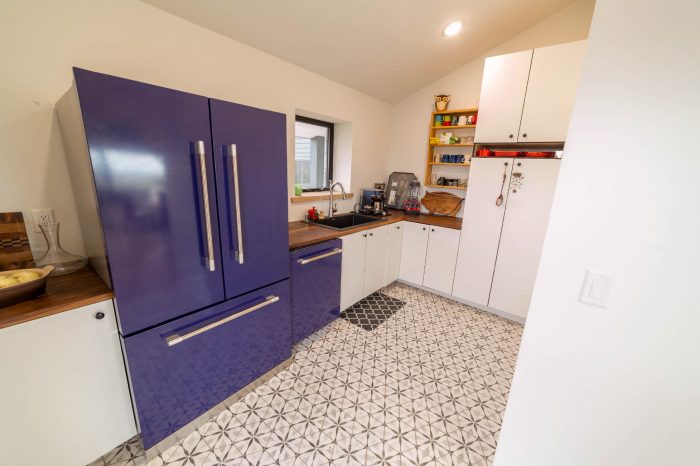 View of the scullery, showing the fridge, cabinets, and sink