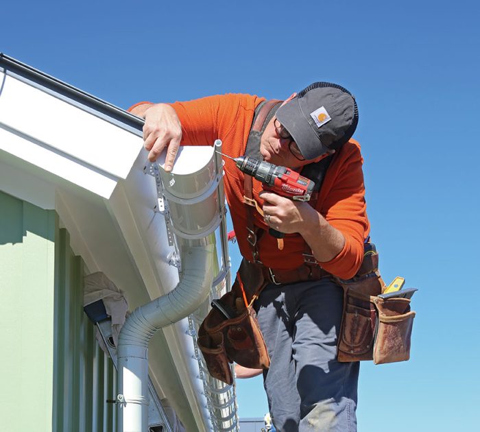 A person installing a gutter