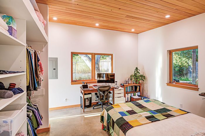 A bedroom with a desk and shelving