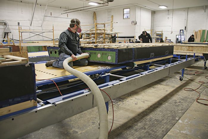 Image of someone filling the cavity of a wall of a panelized house