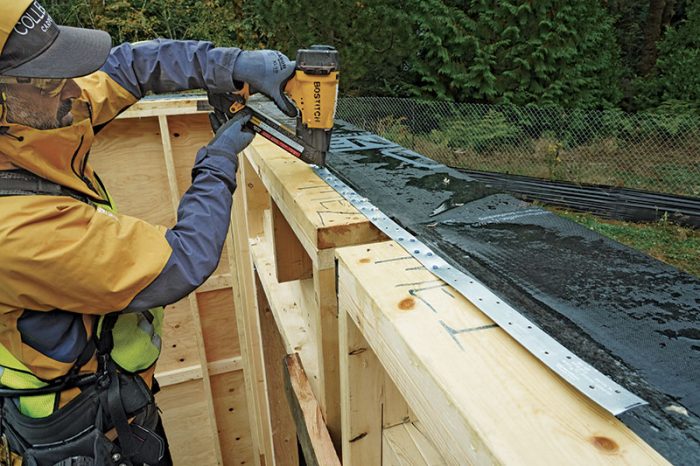 A person connects metal straps to the panels