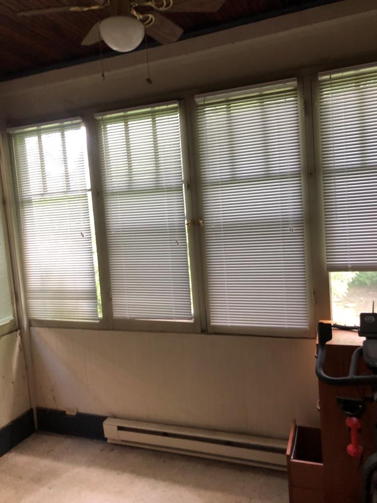 Image of four windows across one wall with the blinds down.