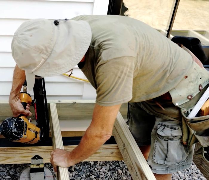 Photo of Mike Guertin screwing the deck frame into place.