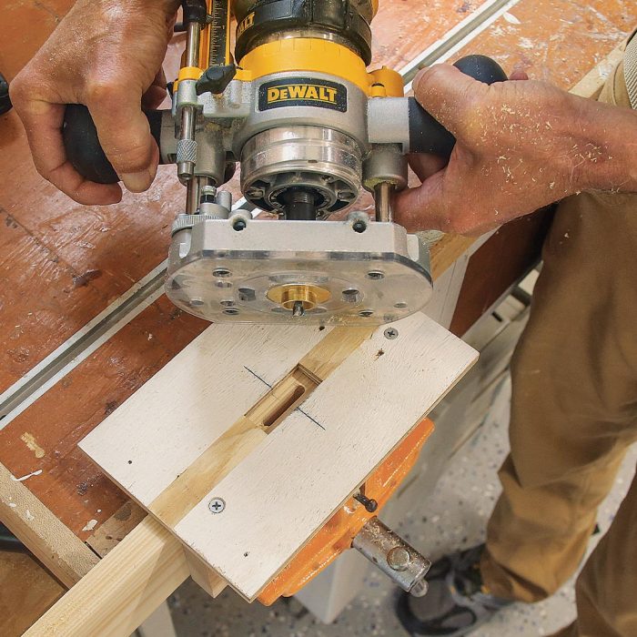 Photo of hands holding a router to mortise stiles.