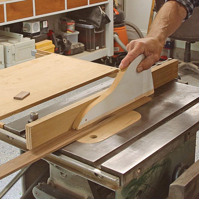 A photo of hands cutting a piece of wood to width.