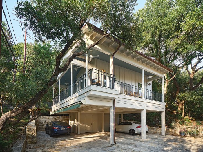 A photo of an Austin, Texas accessory dwelling unit painted off-white featuring a wrap-around porch.