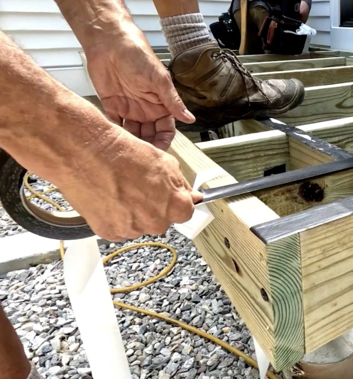 Photo of Mike Guertin installing blocking on a deck frame.