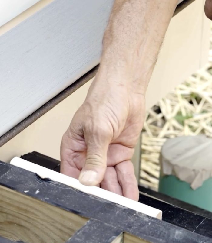 Photo of a hand adding spacers to a deck before adding boards.