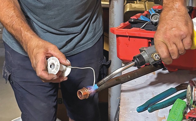 Photo of Mike Lombardi soldering the copper trunk.