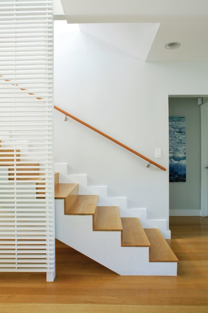 Photo of a modern staircase made of wood and painted white.