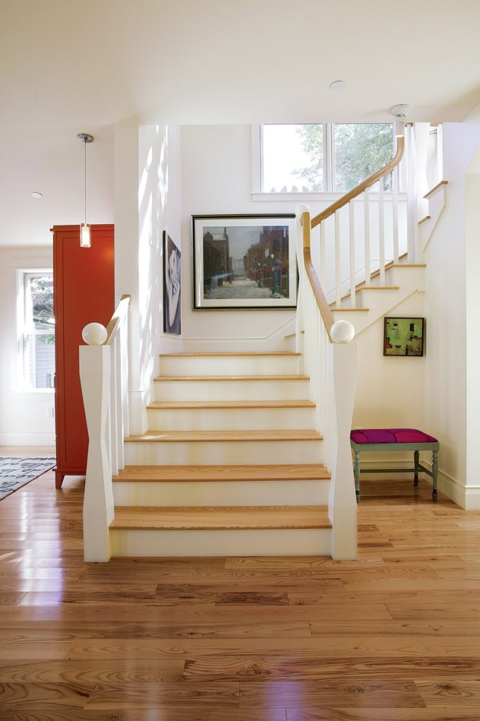 Photo of a traditional staircase made of wood and painted white.