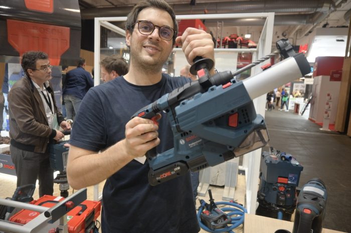 Employee at the Bosch booth shows off the GBH 18V-28 CF Professional SDS Plus cordless hammer drill.