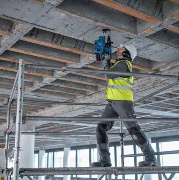 Photo of a man drilling overhead using a Bosch power tool.