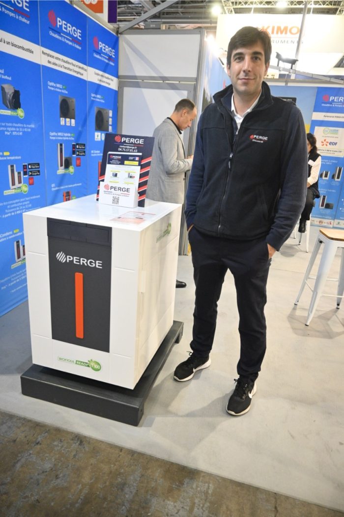 Photo of William Perge standing before his company’s signature F100 biofuel-ready boiler.