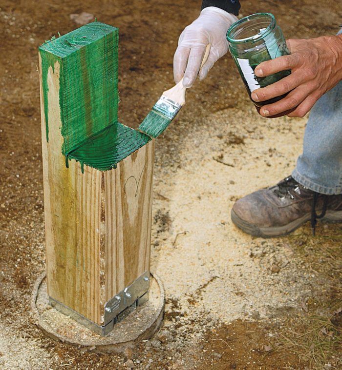 Photo of someone treating lumber with copper naphthenate as required by the International Residential Code.