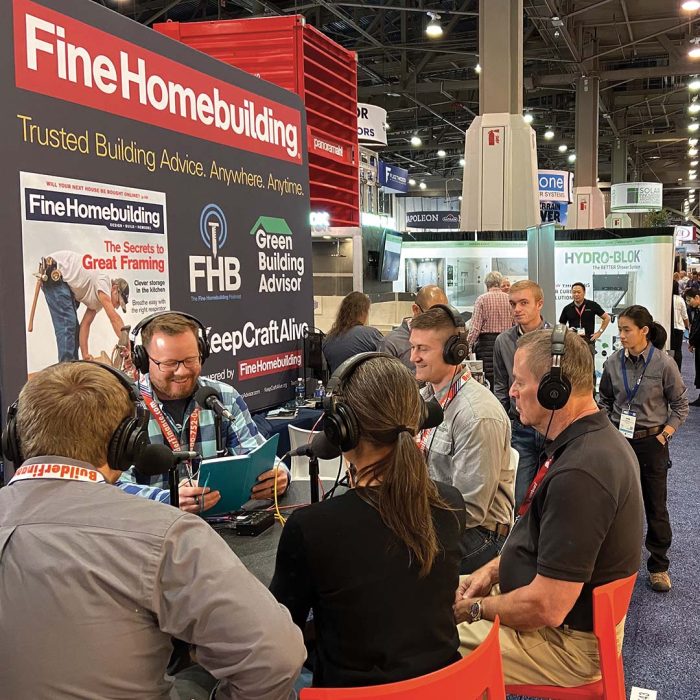 Photo of people gathered around a Fine Homebuilding booth at a trade show.