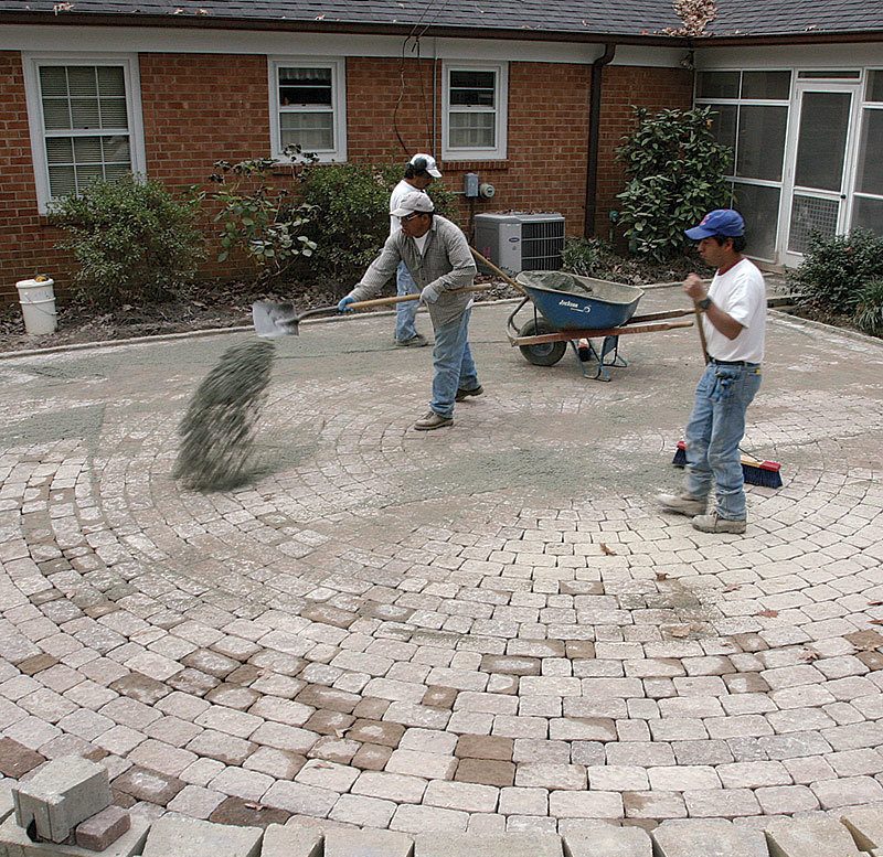 spreading sand into cracks of pavers