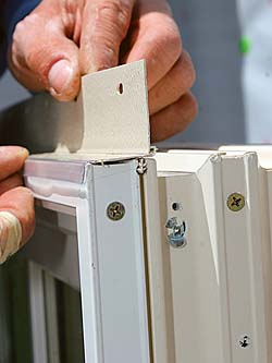 Hinged mechanical flanges on vinyl and metal-clad windows